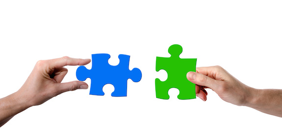 Two hands holding matching puzzle pieces