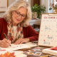 Nonprofit professional woman writing thank you notes at her desk with an October calendar open on her desk