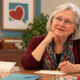 Elizabeth at her desk wondering how many letters she can write to a donor without bothering them.