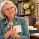 Elizabeth feeling shy and holding a pen and envelope